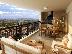 a balcony with chairs, table and couches overlooking the city