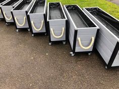 six metal boxes with handles and gold painted faces on them, lined up in a row