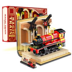 a toy train set is shown in front of an open box with the contents inside