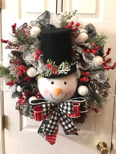 a christmas wreath with a snowman wearing a top hat