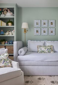 a living room filled with white furniture and lots of pillows on top of the couch