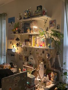 a cluttered home office with shelves and plants