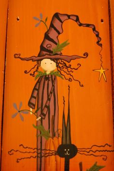 a painting on the side of a wooden door with a scarecrow and black cat