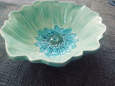 a blue flower shaped bowl sitting on top of a table