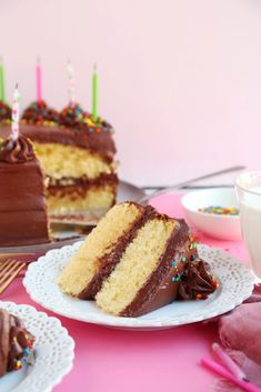 a slice of cake on a plate with chocolate frosting and sprinkles