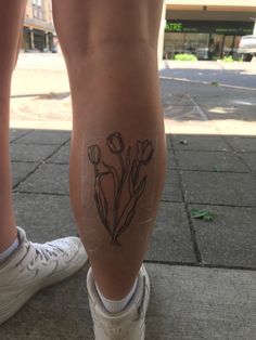 tulip tattoo :)) Non Animal Tattoo, Tattoo Ideas Trendy, Upper Thigh Patchwork Tattoo, Tulip Tattoo Aesthetic, Dainty Calf Tattoos For Women, Naturistic Tattoos, Mt Joy Tattoo, Folk Tattoo Indie, Minimalist Sleeve Tattoo For Women