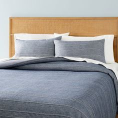 a bed with blue and white linens in a bedroom