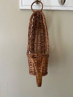 a wicker basket hanging from a hook on a wall