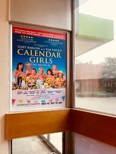 a movie poster hanging on the side of a window sill in front of a building