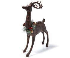 a statue of a deer with pine cones and berries on its antlers is shown