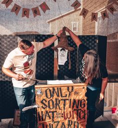 two people standing in front of a sign that says, only sorting hate and wizard