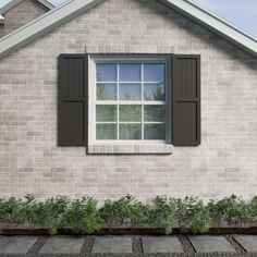 a brick house with black shutters on the windows