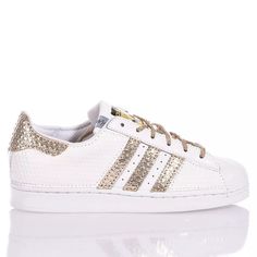 Adidas Superstar White Hive is the super glamorous custom women's sneaker. Entirely in white eco-leather with a geometric texture, featuring the iconic adidas stripes and a textured gold laminated back paired with round gold lurex laces. Adidas Superstar White Hive will also be provided with its original laces. Sporty Gold Sneakers With Perforations, Gold Sneakers With Foil Embossed Logo And Round Toe, White Leather Sneakers With Foil Embossed Logo, Gold Low-top Sneakers With Perforations, Geometric Texture, Zegna Shoes, Sneaker Wedge, Custom Shoes, Manolo Blahnik