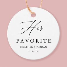 a white ceramic ornament with the words he's favorite on it, hanging from a string