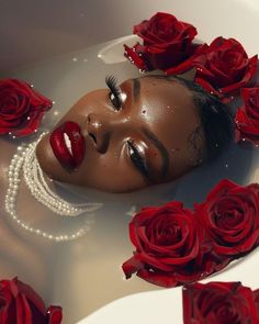 a woman with red lipstick and pearls floating in a tub filled with water surrounded by roses