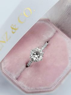 an engagement ring in a pink velvet box