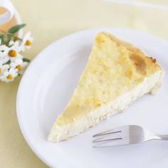 a piece of pie sitting on top of a white plate next to a fork and cup