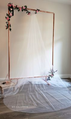 a wedding arch decorated with pink roses and greenery