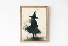 a black and white photo of a woman in a witches hat