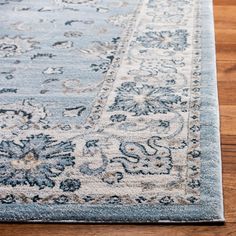 a blue and white rug with an ornate design on the bottom, sitting on a wooden floor