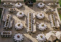 an aerial view of tables and chairs set up for a formal function with umbrellas