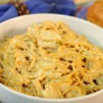 a white bowl filled with macaroni and cheese sitting on top of a table