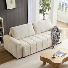 a living room with a white couch and coffee table in front of a bookcase