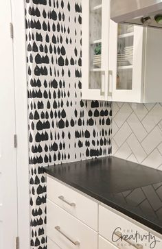 a kitchen with black and white wall paper