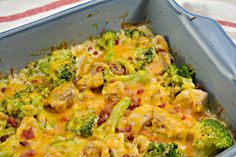 a casserole dish with broccoli, cheese and bacon in it on a striped cloth