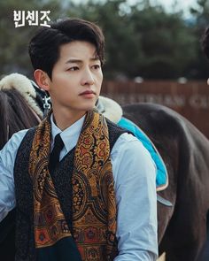 a young man sitting on top of a horse wearing a bandana and holding the reins