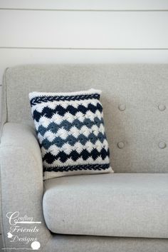 a gray couch with a black and white pillow on it