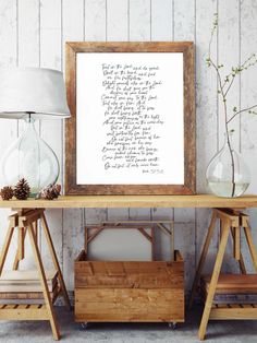 a wooden table topped with two vases and a framed print on top of it