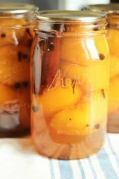 three jars filled with fruit sitting on top of a table