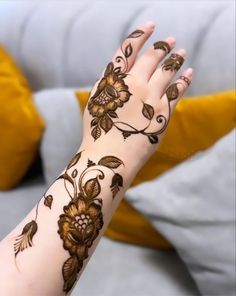 a woman's hand with hennap on it and flowers painted on the arm