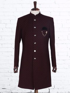 a mannequin dressed in a maroon coat with black polka dots on the front