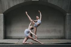 two women are doing yoga on the street