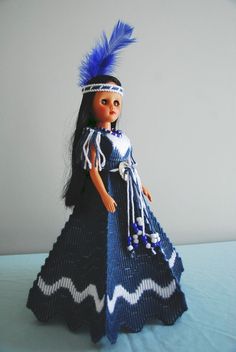 a doll wearing a blue dress and headdress