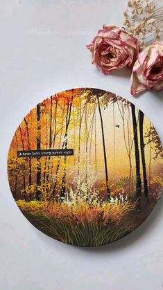 there is a painting on the back of a coaster that has flowers in front of it