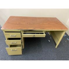 a wooden desk with three drawers on the bottom and one drawer below it, sitting on carpeted flooring