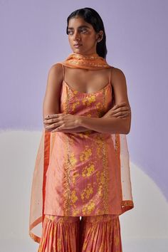 Coral orange noodle strap sleeves kurta in cotton silk base with all over bloomy print with dabka, beads embroidered highlights. Paired with matching tiered sharara and organza dupatta.
Components: 3
Pattern: Print, Embroidery
Type Of Work: Hand Block, Dabka and Beads
Neckline: Round
Sleeve Type: Noodle Strap
Fabric: Kurta and Sharara: Cotton Silk, Dupatta: Organza
Color: Orange
Other Details: 
Length(in inches):
Kurta: 32
Sharara: 44
Dupatta: 38
Occasion: Puja - Aza Fashions Kurta And Sharara, Noodle Strap, Kurta Sharara Set, Kurta Sharara, Print Embroidery, Beaded Neckline, Sharara Set, Organza Dupatta, Silk Dupatta