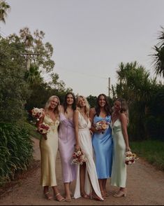 four bridesmaids pose for a photo in their dresses