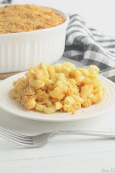 a white plate topped with macaroni and cheese next to a casserole dish