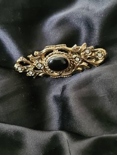 Celtic style with jet black stone (untested)  Vintage broach.  Beautiful gold tone.  Scottish vintage broach with the infinity and in an older victorian style. This has been adored by a lady of long ago and needs loved again as it has a story to tell and has more stories to see.  All my items are locally sourced here in Scotland and ready to go anywhere in the world Classic Black Brooches For Wedding, Classic Black Wedding Brooch, Classic Black Brooches For Formal Occasions, Classic Black Wedding Brooches, Classic Black Formal Brooches, Antique Black Brooch For Gift, Victorian Black Brooches As Gift, Victorian Black Brooches For Gifts, Victorian Style Black Brooches For Gifts