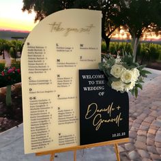 a wedding ceremony sign with flowers on it next to a welcome sign for the bride and groom