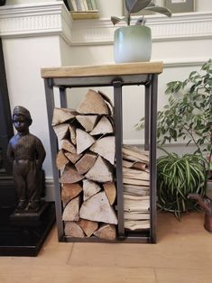 a stack of firewood sitting on top of a wooden floor next to a statue