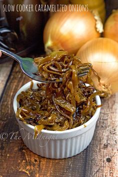 slow cooker caramelized onions in a white bowl with a spoon on the side