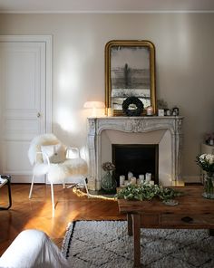 a living room filled with furniture and a fire place in front of a painting on the wall