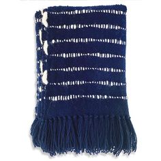 a blue and white knitted blanket with fringes on the bottom, in front of a