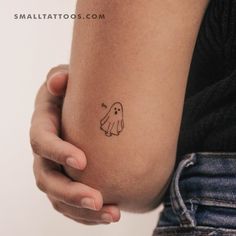 a person holding their arm with a small tattoo on it's left side,