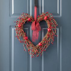 a heart shaped wreath hangs on the front door